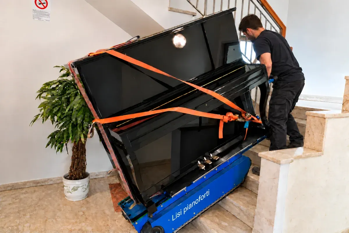 Pianoforte verticale fissato all’attrezzatura per il trasporto sulle scale